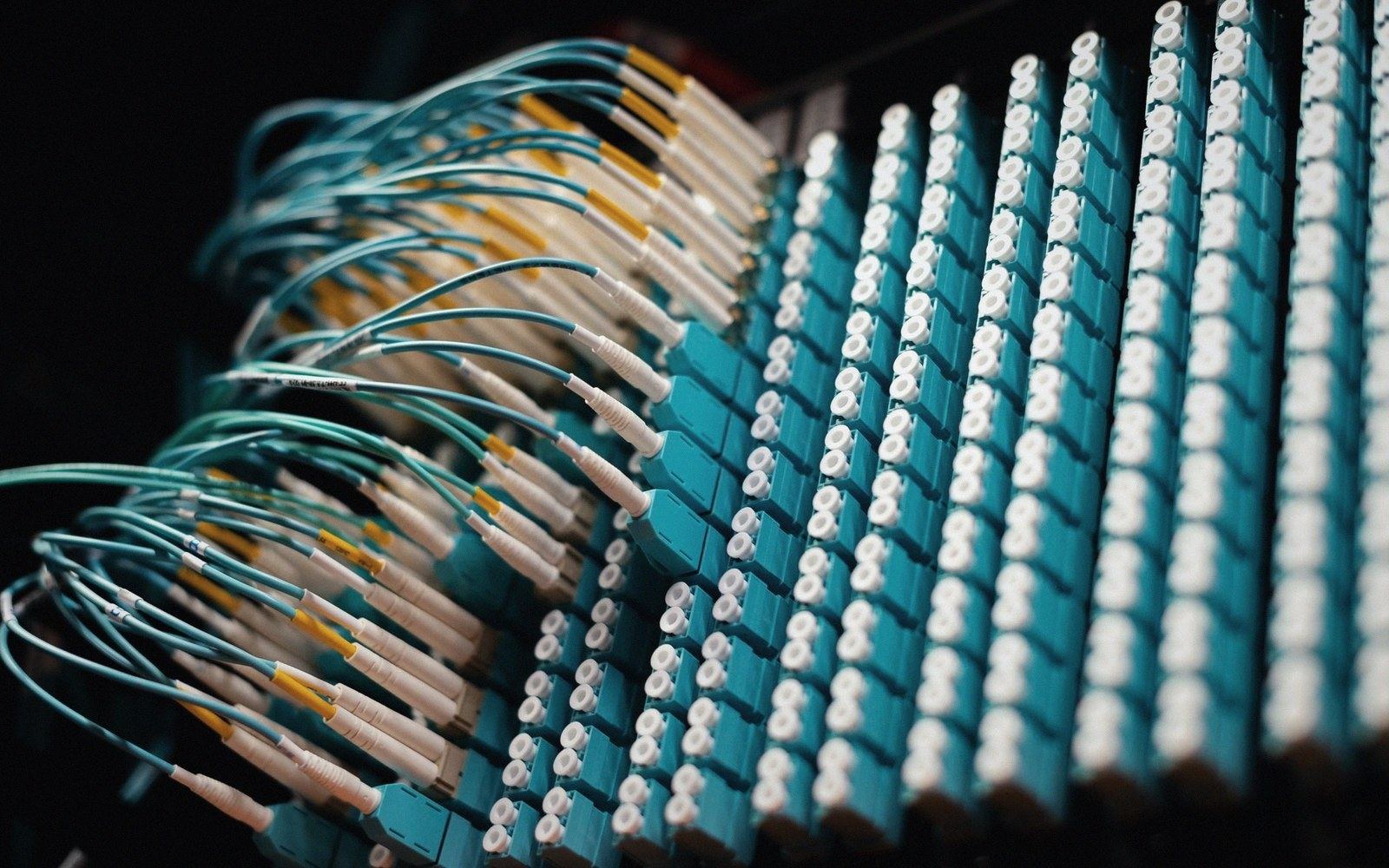 A close-up of a fibre optic patch panel with labelled LC connectors in a grey steel chassis
