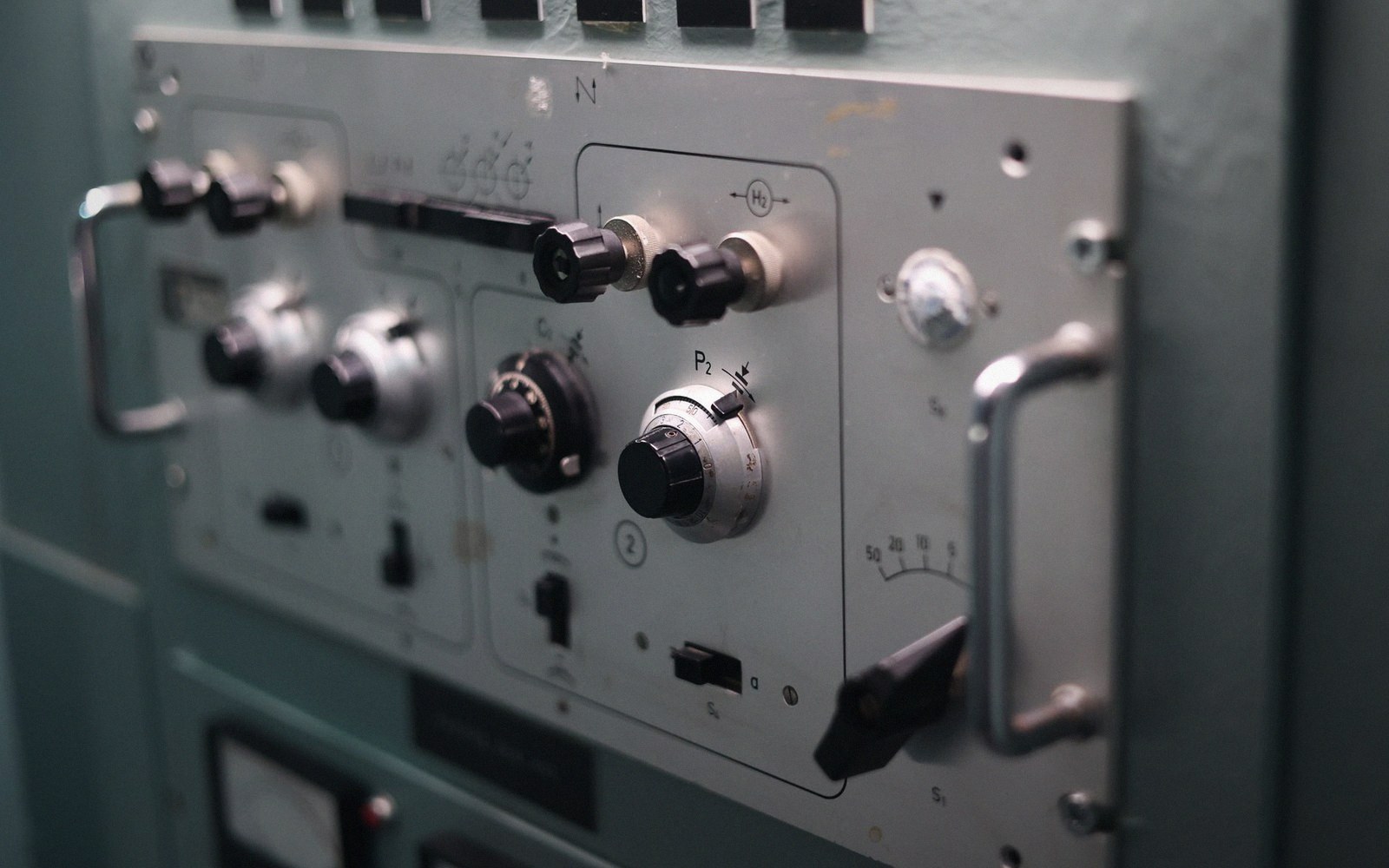Close-up of an analog control panel with dials, knobs and a small gauge
