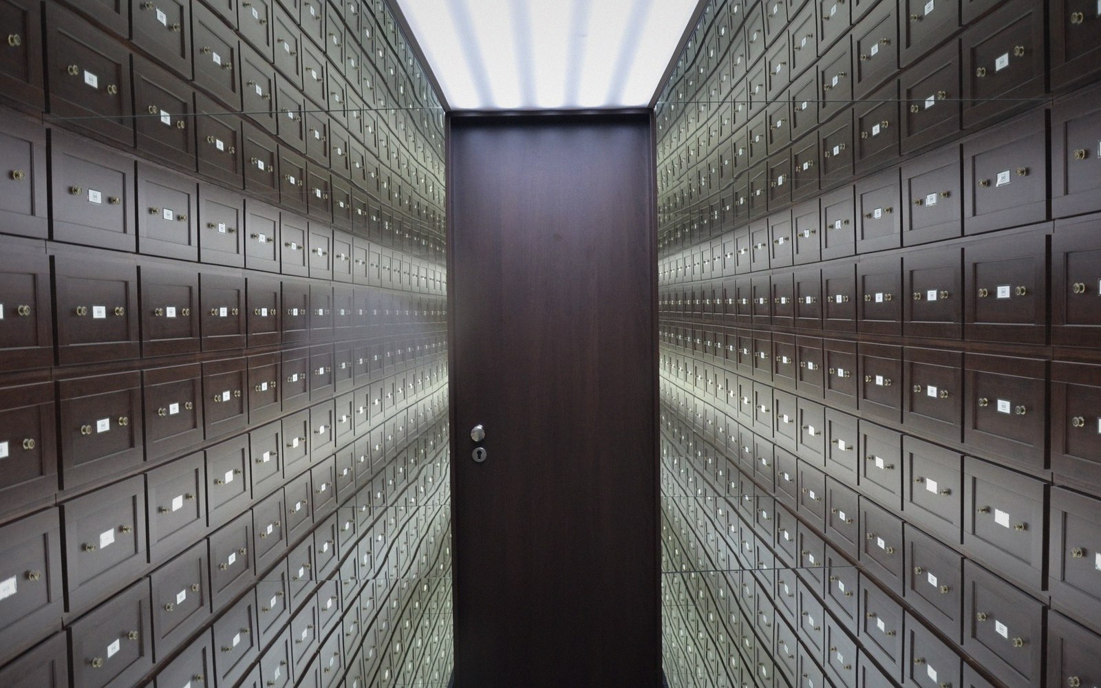 A hot-aisle containment door in a datacentre, partially open, warm orange light visible through the gap